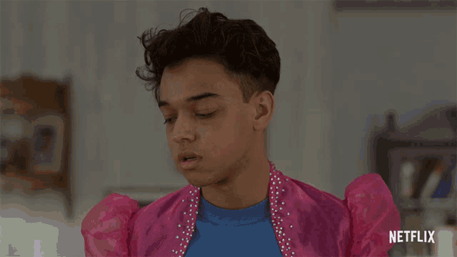 a young man wearing a pink jacket and a blue shirt with netflix written on the bottom