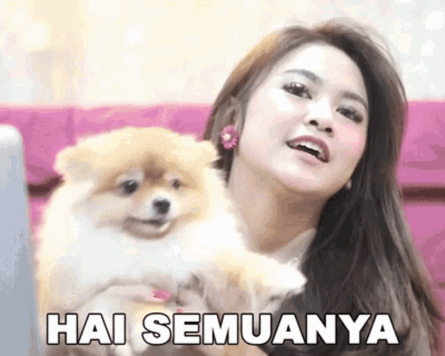 a woman is holding a small dog with the words hai semuanya written on the bottom