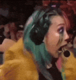 a woman with green hair is wearing headphones in a crowd