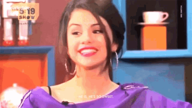a woman is smiling in front of a sign that says 5:19 show on it