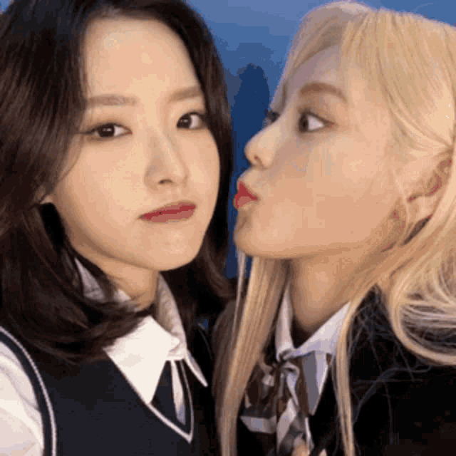 two girls in school uniforms are kissing each other on the cheeks