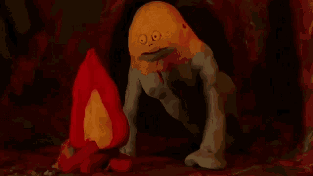 a clay monster with a yellow face is crawling on the ground .
