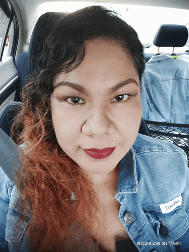 a woman wearing a calvin klein denim jacket smiles for the camera
