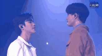 a couple of men are standing next to each other on a stage .