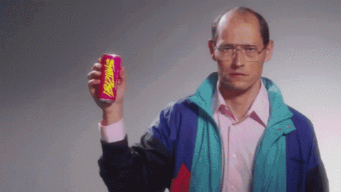 a man wearing glasses is holding up a can of snickers
