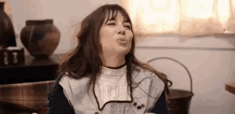 a woman is making a funny face while sitting on a couch .
