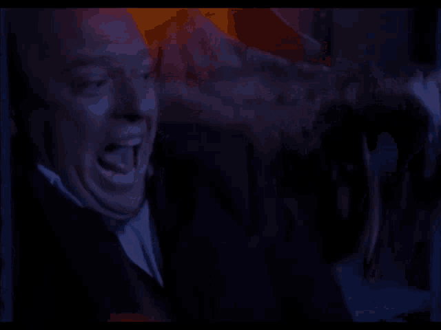 a man in a suit and tie is screaming with his mouth open
