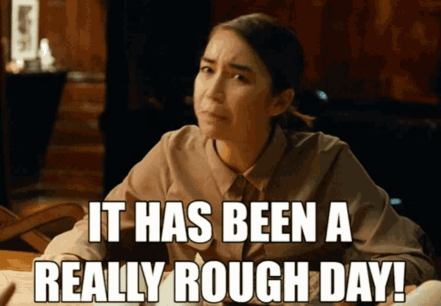 a woman sitting at a desk with the words " it has been a really rough day "