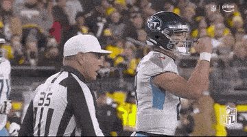 a football player is standing next to a referee during a game .