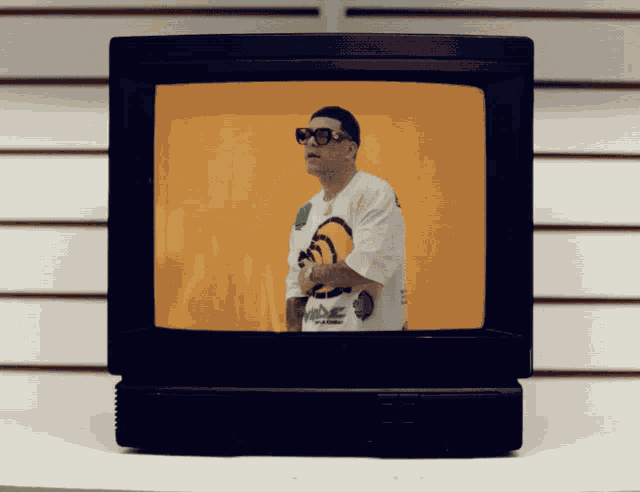 a man wearing sunglasses and a white shirt that says " mede " on it