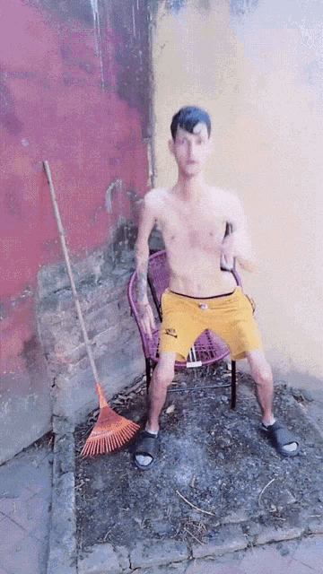 a shirtless man in yellow shorts is sitting in a chair