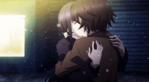a man and a woman are hugging each other in a dark room