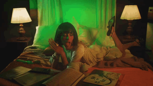 a woman is laying on a bed with a green light on