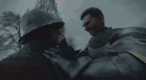 a man in a knight 's armor is fighting a group of zombies in the rain .