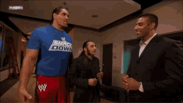 a man wearing a blue shirt that says smack down on it