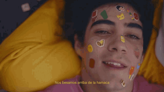 a man with stickers on his face and the word mmmmh on the bottom right