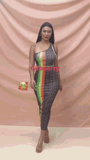 a woman in a multicolored dress is standing in front of a pink curtain with the word girl merry written on it