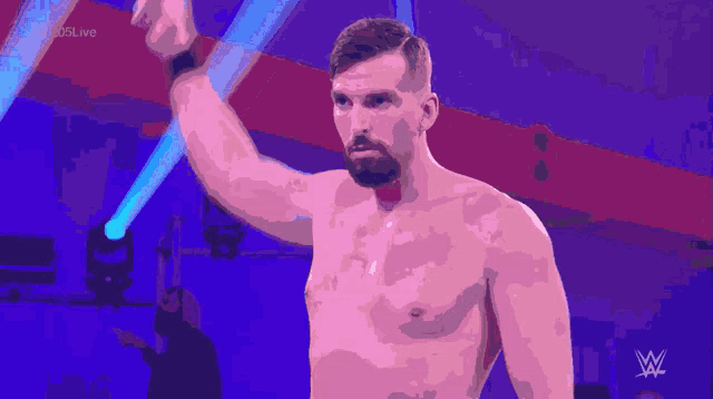 a man without a shirt is standing in front of a spotlight with the letters w on the bottom right