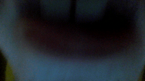 a blurry picture of a person 's face with a yellow sweater on