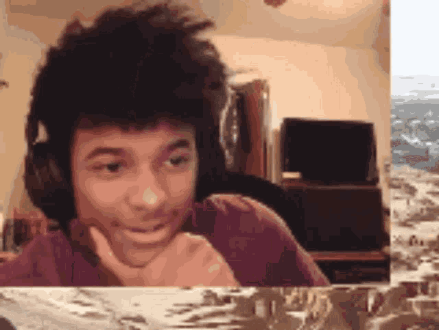 a young man wearing headphones looks at the camera and smiles