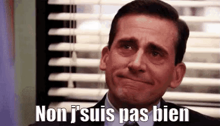 a man in a suit and tie is crying in front of a window .