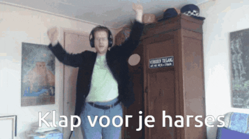 a man wearing headphones is dancing in a room with the words klap voor je harses on the bottom