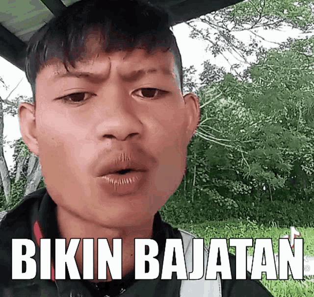 a young man says bikin bajatan in front of a forest