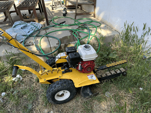 a yellow lawn mower with a honda engine