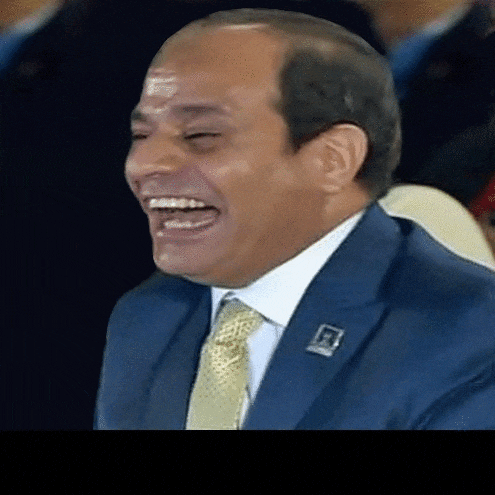 a man in a blue suit and tie is laughing
