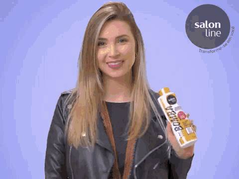 a woman in a leather jacket holds a bottle of bomba shampoo
