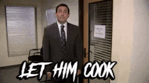 a man in a suit and tie is standing in front of a door that says let him cook