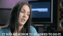 a woman says " it was an honor to be asked to do it " in front of a monitor