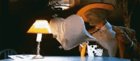 a man in a cowboy hat is sitting at a table with a lamp on it .