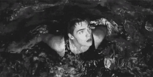a man is swimming in a pool with his arms outstretched .
