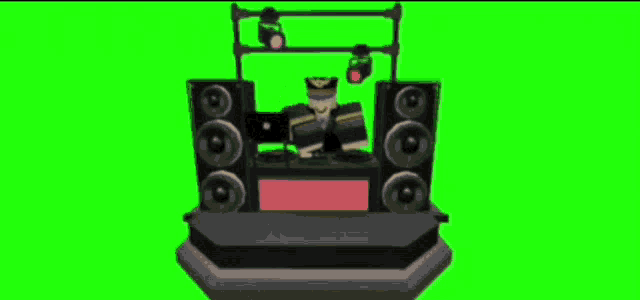 a dj is sitting at a table with speakers and a green screen behind him .