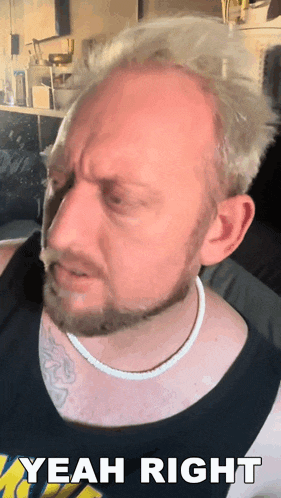 a man with a beard and a tattoo on his chest says yeah right