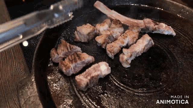 some meat is being cooked on a pan with the words made in animotica visible