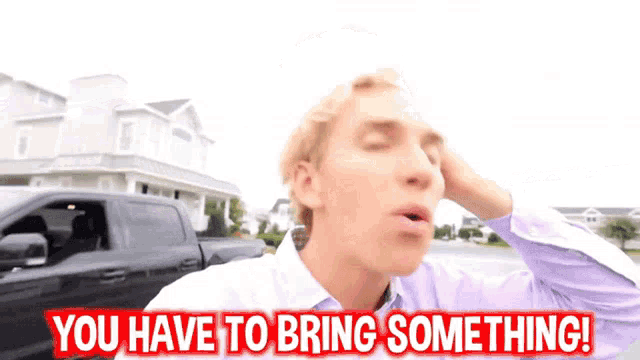 a man is standing in front of a truck and says you have to bring something