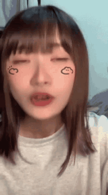a close up of a girl 's face with a cloud drawn on her face