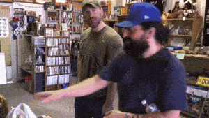 two men in a store with a sign that says dog