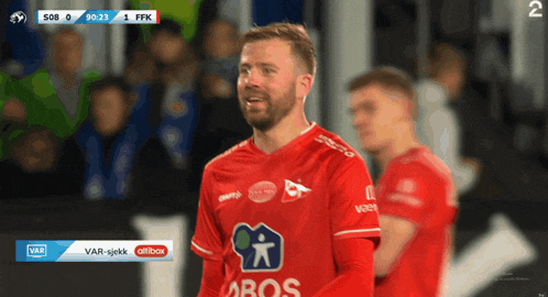 a soccer player wearing a red shirt that says bos on it