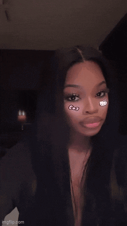 a woman with hello kitty stickers on her face looks at the camera