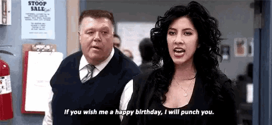 a man and a woman are standing next to each other in a room . the woman is yelling at the man .