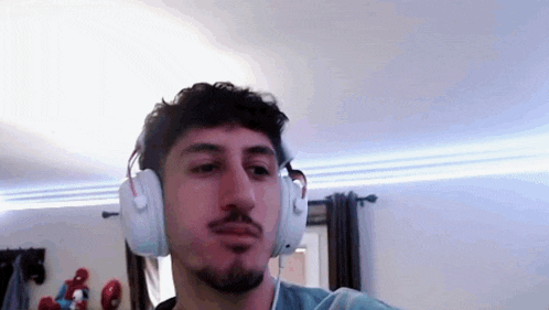 a man with a beard is wearing headphones in a room .