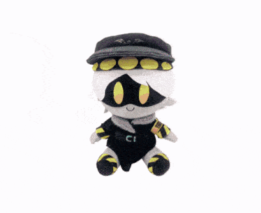 a hand is holding a stuffed animal with yellow eyes and a white hat .