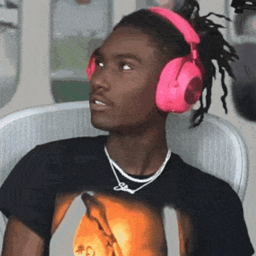 a man wearing pink headphones and a black shirt with a picture of a man on it