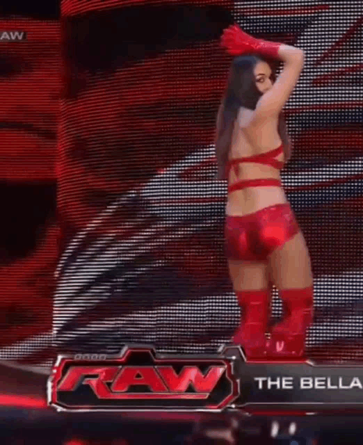 a woman is standing on a stage in front of a raw sign .
