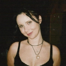 a woman wearing a black tank top and a necklace with a pearl pendant