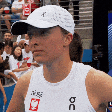 a woman wearing a white hat and a white tank top that says nfsys