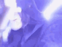 a person is smoking a cigarette in a dark room with a purple light behind them .